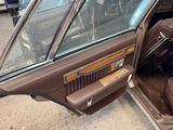 a brown car with its door open on the side of the road