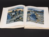 an open book on a black surface with two pictures of people on it