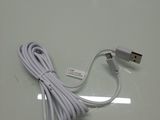a white cable connected to a charger on a table