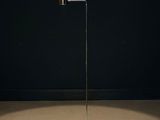 a lamp that is sitting on top of a floor next to a wall