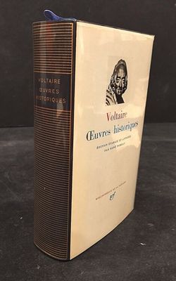 an old book sitting on top of a table next to a black background