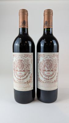 deux bouteilles de vin rouge posées l'une à côté de l'autre sur une surface blanche
