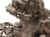 a bronze statue of a dog with a ball in it ' s mouth