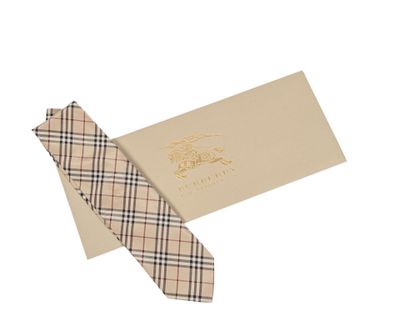 La cravate est de couleur beige et noire, avec un motif à carreaux.