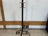 lampadaire en fer forgé muni d'un bougeoir, posé sur un sol en marbre