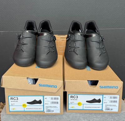 deux paires de chaussures noires sont posées sur des cartons