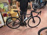 un homme debout à côté d'un vélo dans un magasin