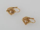 two pairs of gold earrings with pearls on them