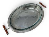 a silver tray with a wooden handle on a white surface