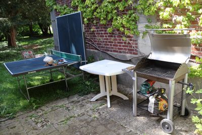 un barbecue avec une table et une table de ping-pong dans le jardin