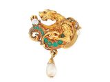 a close up of a broochle with a dragon and a pearl