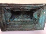 a picture of a small bronze box with a hole in it