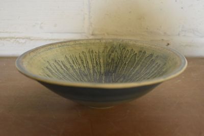 a green and black bowl sitting on a table