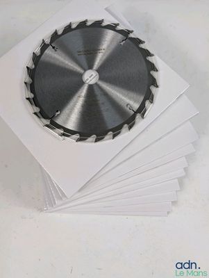 plusieurs feuilles de papier blanc sur lesquelles repose une lame de scie circulaire