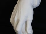 sculpture of a hand holding a ball on a black background
