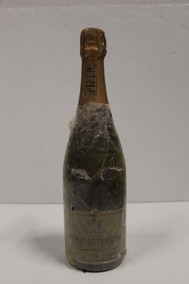 an old bottle of champagne sitting on top of a white table