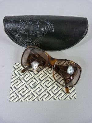 pair of brown sunglasses and a black case on a white table