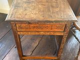 an old wooden table sitting on top of a wooden floor next to a chair