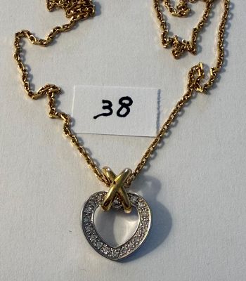 collier composé d'un cœur et d'une croix suspendus à une chaîne, sur laquelle est accrochée une étiquette de prix