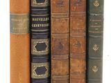 plusieurs vieux livres sont alignés sur une surface blanche
