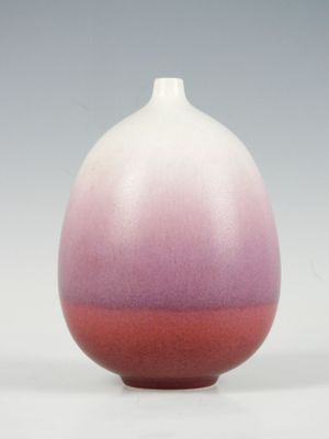 un vase blanc et rose posé sur une table blanche
