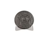 a close up of a coin on a stand on a white surface