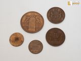 four different coins sitting on top of a white surface next to each other