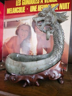 un livre posé sur une étagère à côté d'une statue de dragon
