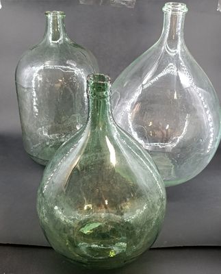 three green glass vases sitting next to each other on a table