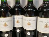 six bouteilles de vin rouge sont alignées sur une table