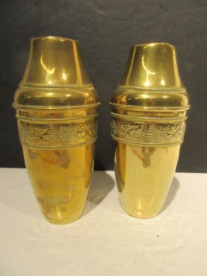 two gold vases sitting on a white table