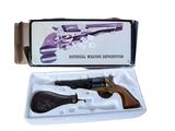 un pistolet dans une boîte sur fond blanc, avec une crosse noire