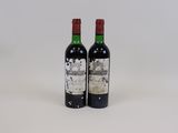 deux bouteilles de vin posées l'une à côté de l'autre sur une surface blanche