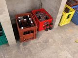 several crates of soda are lined up against a concrete wall