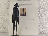 a statue of a man standing next to a certificate