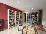 un salon équipé d'un canapé, d'un fauteuil et d'une bibliothèque