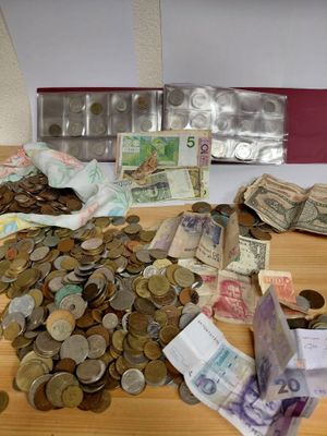 a pile of money sitting on a table next to a bag of coins