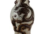 un vase orné d'un dragon sur fond blanc