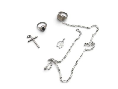 a silver necklace, ring, and other jewelry on a white surface
