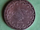 an old coin with a bird on it sitting on a green surface