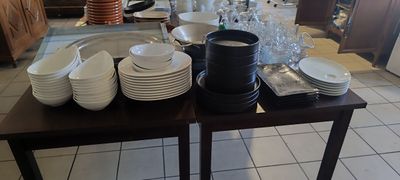 une table sur laquelle sont posées de nombreuses assiettes et verres