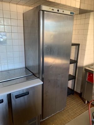 un réfrigérateur dans une cuisine équipée d'un évier et d'un lave-vaisselle