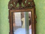 a mirror hanging on a green wall with a wooden frame