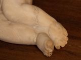 a small statue of a baby sitting on a wooden table