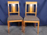 une paire de chaises en bois avec des assises rembourrées de couleur marron