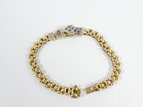a close up of a gold bracelet with a cross on it