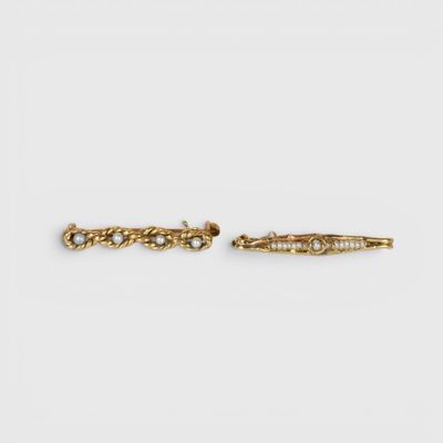 a pair of gold earrings with pearls on them