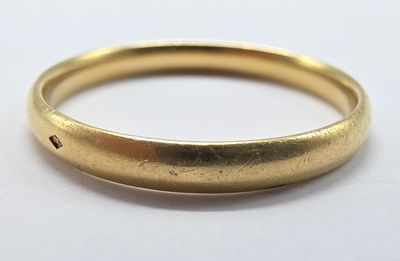 gros plan d'une bague en or sur une surface blanche