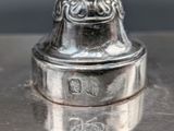 a silver bell sitting on top of a metal table