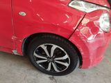 a red car that has been dented and is parked in a garage